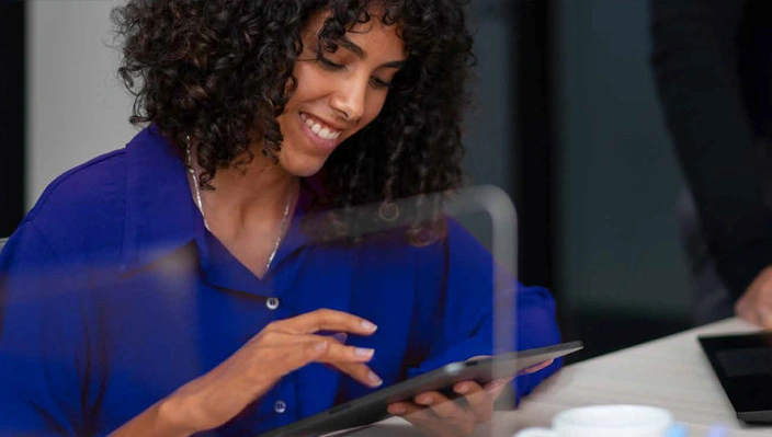 Profissional sorrindo enquanto usa um tablet